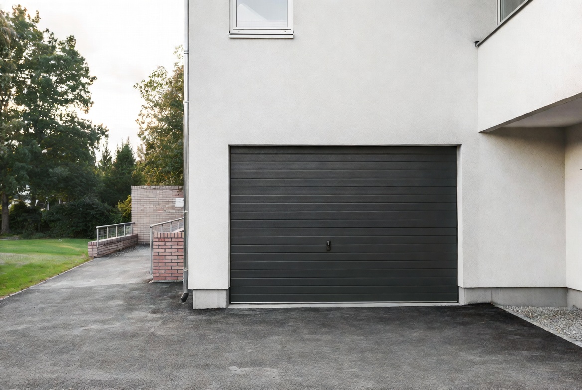 Modern antracitfärgad garageport på villa